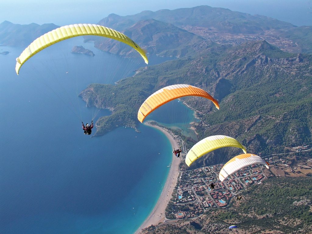 What are the top travel destinations for paragliding and skydiving?